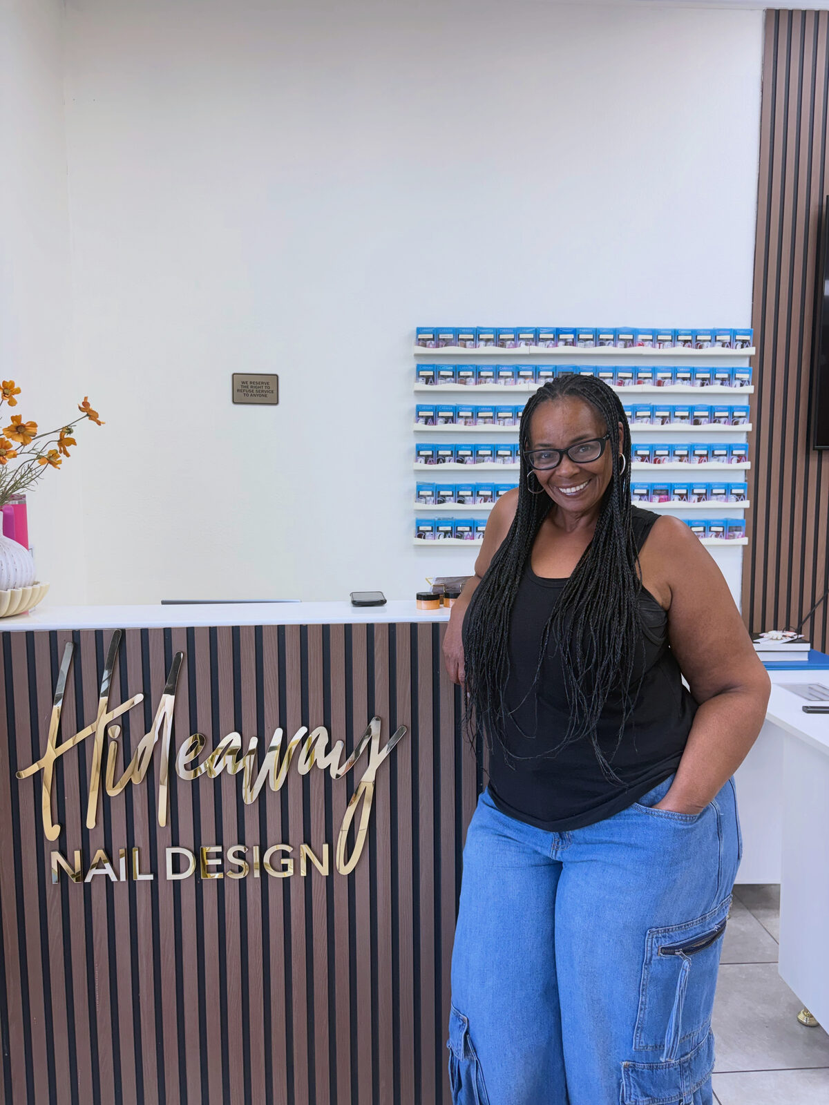 Owner of Hideaway Nail Design smiling at the front desk