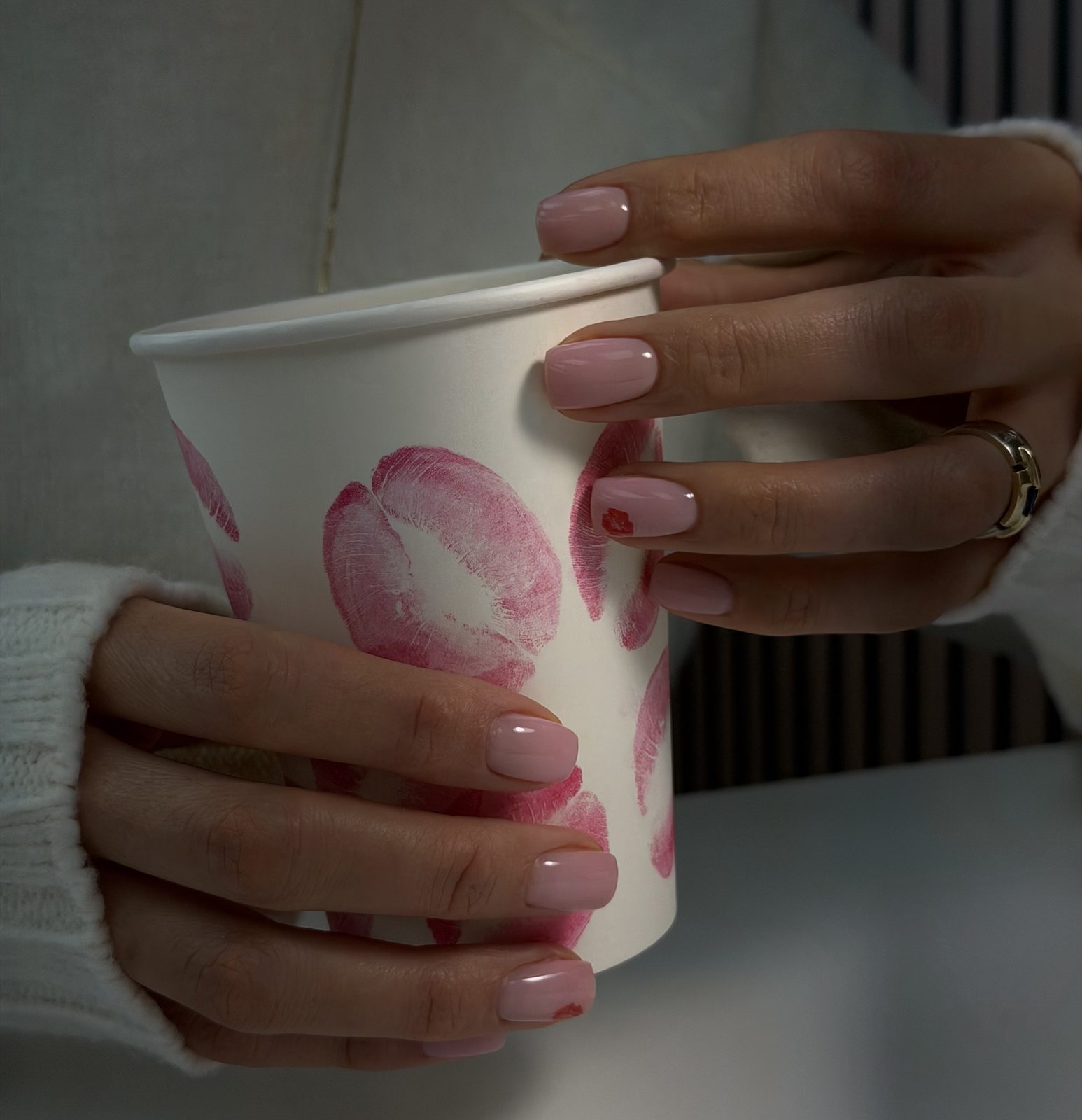 Pink French manicure holding a kiss-marked cup at Hideaway Nail Design